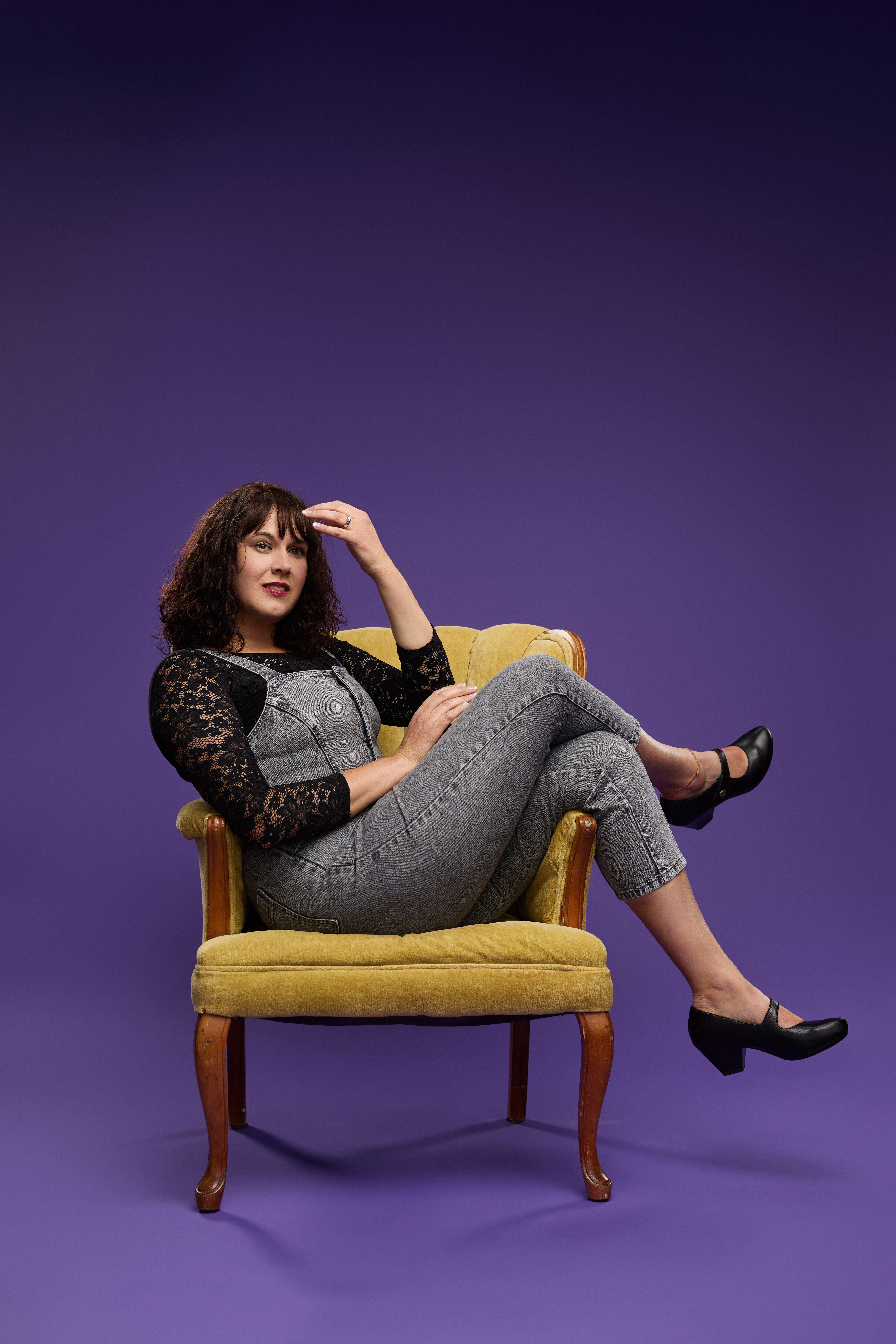 Elise Wayland with a purple background wnd a cool yellow chair