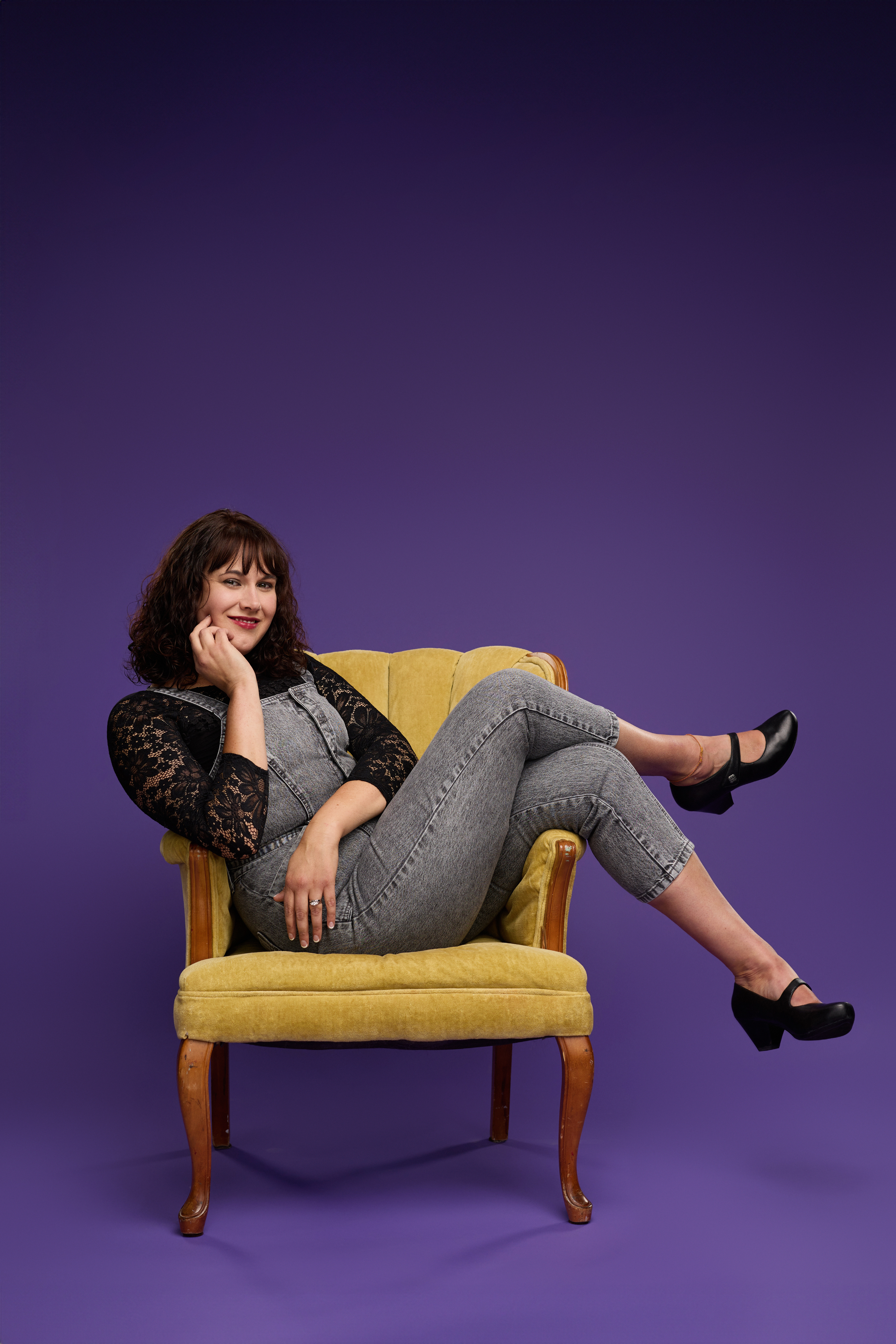 Elise Wayland with a purple background wnd a cool yellow chair